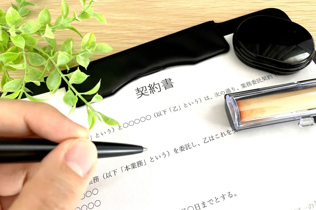 契約書にサインをするビジネスパーソンの手